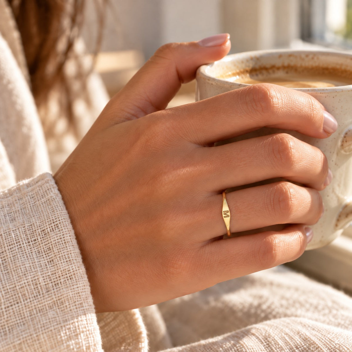 Velmora initial letter ring worn while holding a coffee cup